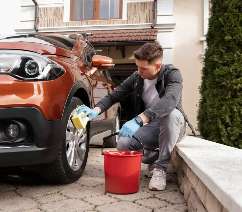 Lavage auto à domicile Saint-Julien-d'Intres : professionnel intervenant sur un véhicule